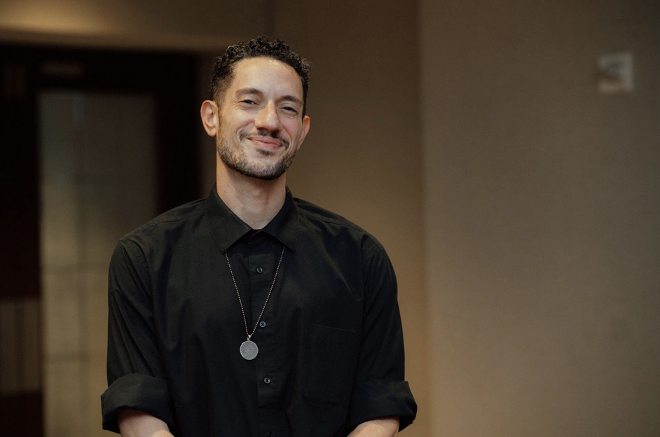 A photo of Pillars Muslim Narrative Change Fellow Omar Offendum wearing a black button-down shirt, smiling at the camera