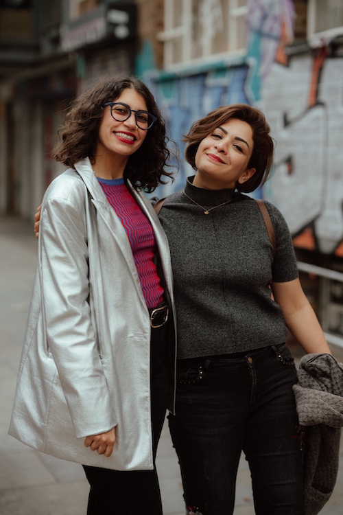 Pillars Artist Fellows Farida Zahran and Fateme Ahmadi smiling with their arms around each other on a street in London