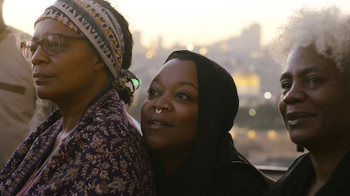 A photo of three women with Jerusalem’s Old City in the background, featuring Tracye Johnson, Drea D'Nur, and Cariol Horne